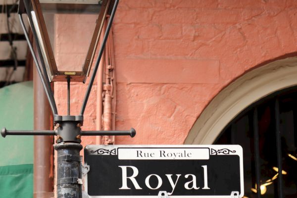 Street lamp and a "Royal" sign on a pink building, likely indicating Royal Street.